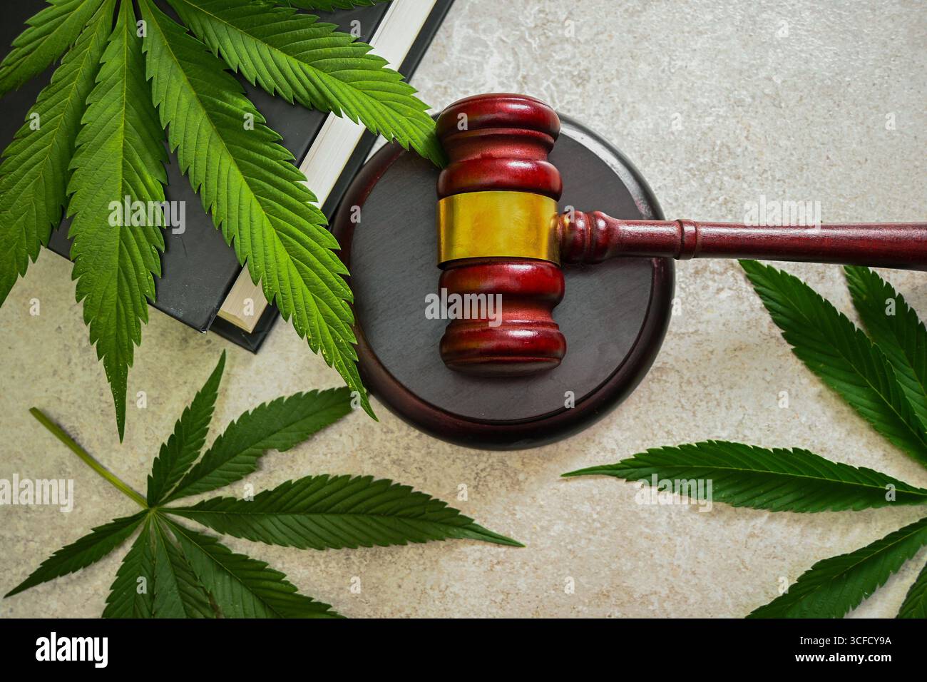 Richter Hamel und Cannabisblätter auf einem Tisch, symbolisiert die Legalisierung von medizinischem Marihuana. Stockfoto