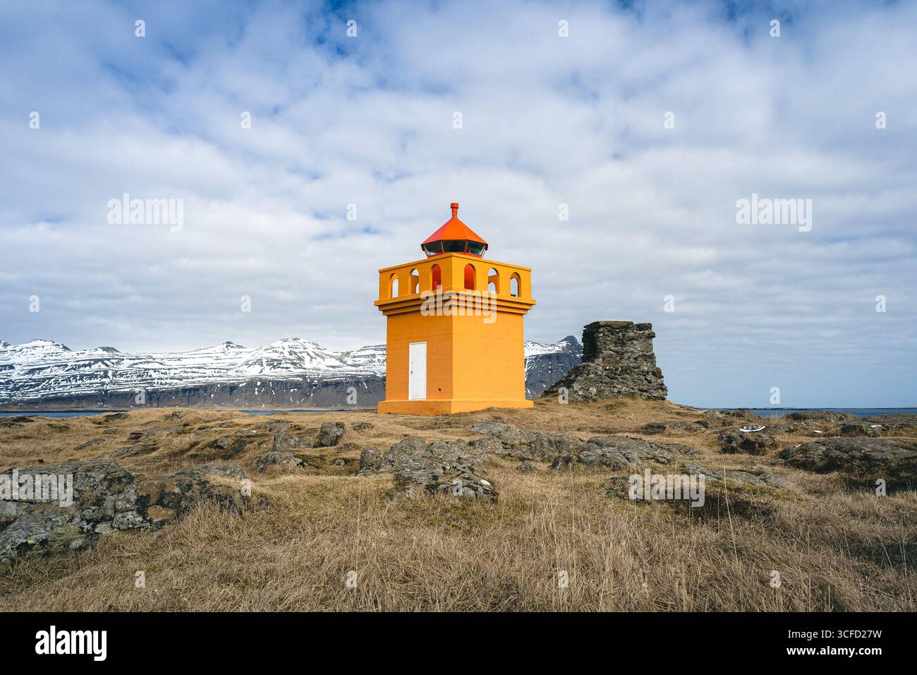 Kleiner orangefarbener Leuchtturm an der Küste islands Stockfoto