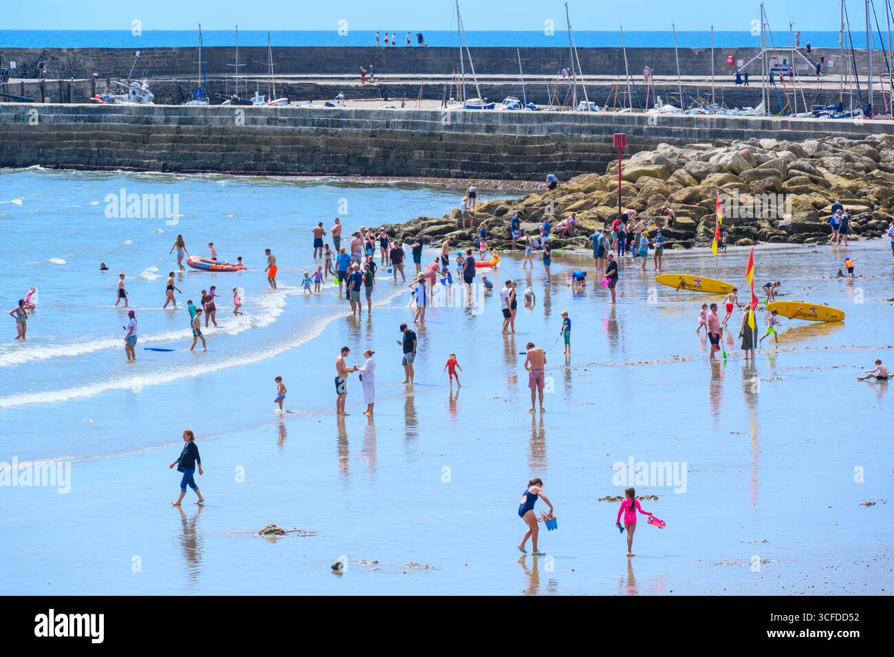 Lyme Regis, Dorset, Großbritannien. August 2025. Wetter in Großbritannien: Urlauber und Familien paddeln im Meer in herrlich heißer Sonne, während das Sommermonatswochenende im August beginnt. Quelle: Celia McMahon/Alamy Live News Stockfoto