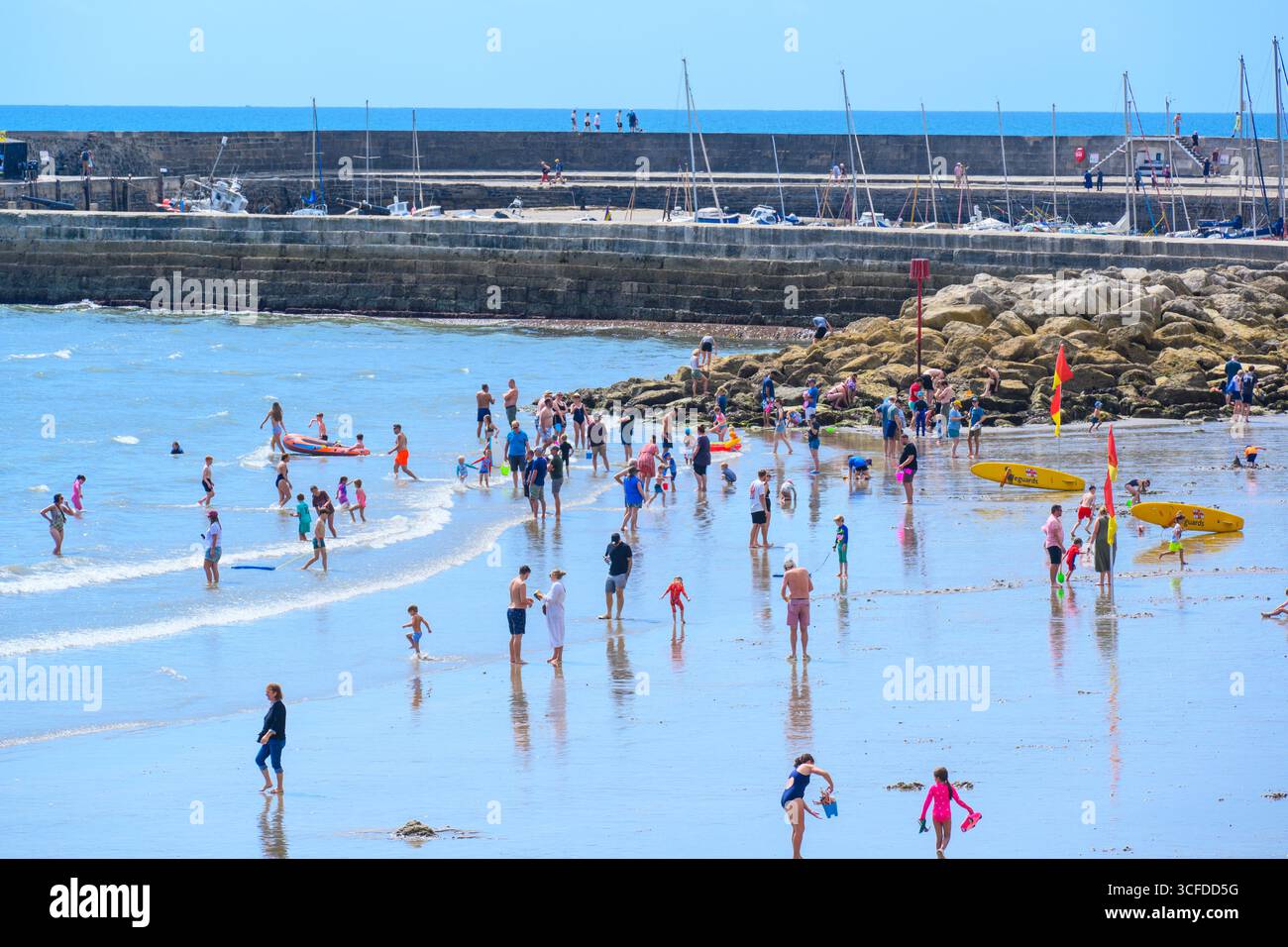 Lyme Regis, Dorset, Großbritannien. August 2025. Wetter in Großbritannien: Urlauber und Familien paddeln im Meer in herrlich heißer Sonne, während das Sommermonatswochenende im August beginnt. Quelle: Celia McMahon/Alamy Live News Stockfoto