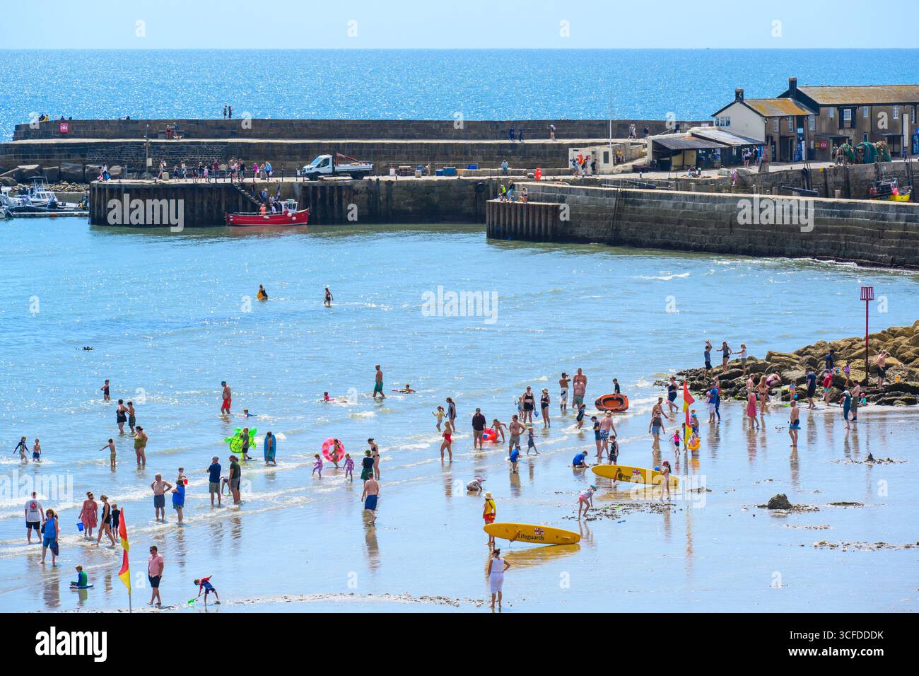 Lyme Regis, Dorset, Großbritannien. August 2025. Wetter in Großbritannien: Urlauber und Familien paddeln im Meer in herrlich heißer Sonne, während das Sommermonatswochenende im August beginnt. Quelle: Celia McMahon/Alamy Live News Stockfoto
