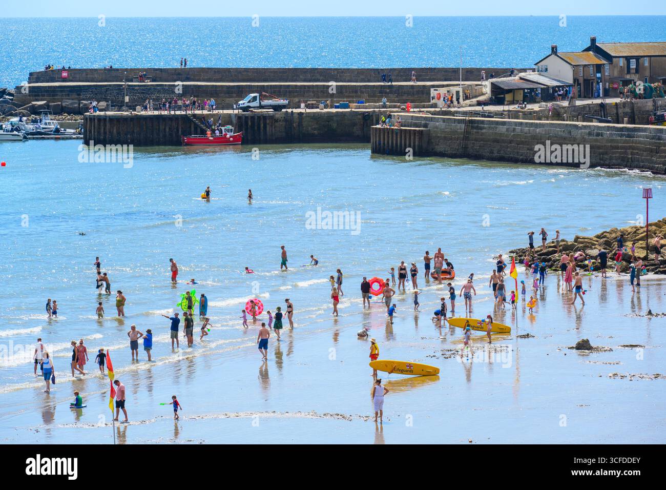 Lyme Regis, Dorset, Großbritannien. August 2025. Wetter in Großbritannien: Urlauber und Familien paddeln im Meer in herrlich heißer Sonne, während das Sommermonatswochenende im August beginnt. Quelle: Celia McMahon/Alamy Live News Stockfoto
