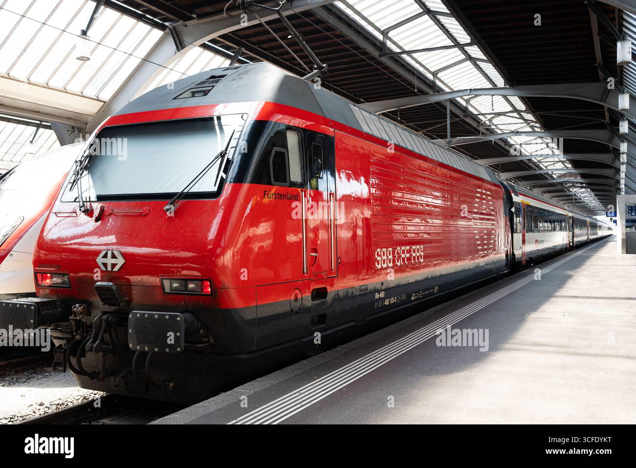 Zürich, Schweiz, 19. August 2025. Geparkte, rote Lokomotive eines Personenzuges im Erdgeschoss des Hauptbahnhofs. Weitwinkelansicht, Metall A Stockfoto