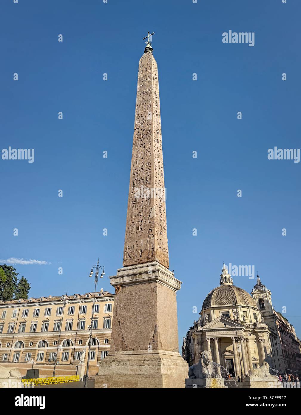 Blick auf den mächtigen ägyptischen Obelisken in Rom, Piazza del Popolo. Das Bild zeigt die antiken Hieroglyphen und eine klassische Kuppelkirche, alle in A Stockfoto