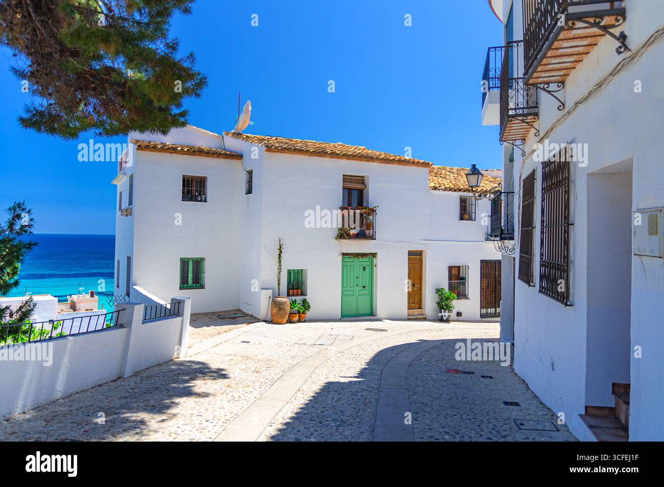 Altea Altstadt enge Straße mit typischen weißen Häusern Gebäude, Altea Bucht Mittelmeer Wasser an sonnigen Sommertagen, Altea Stadt historisches Zentrum, Stockfoto