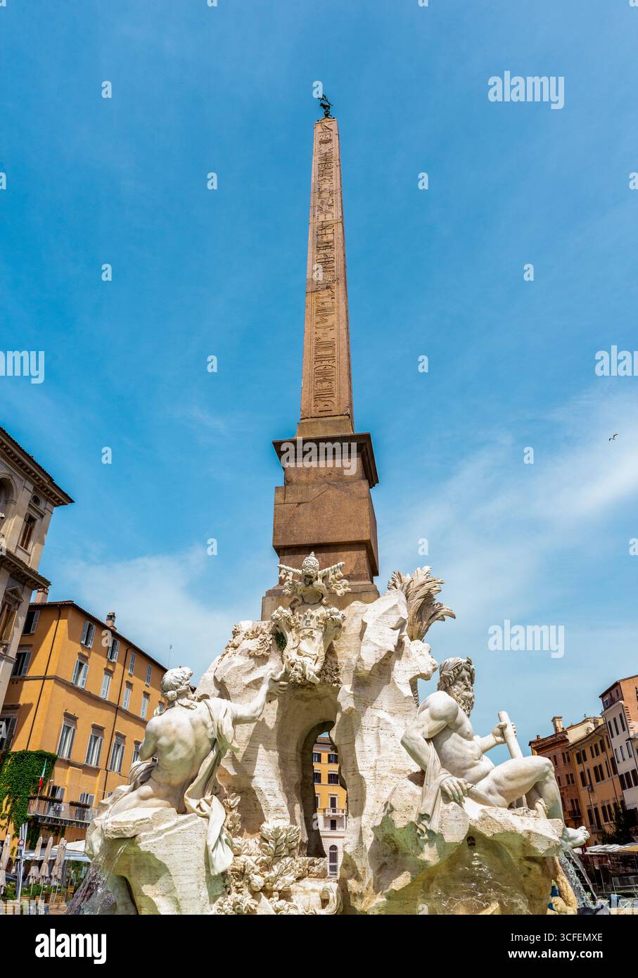 Monumentale Fontana dei Quattro Fiumi mit Obelisk auf der Piazza Navona, Rom, Italien, unter klarem blauem Himmel Stockfoto