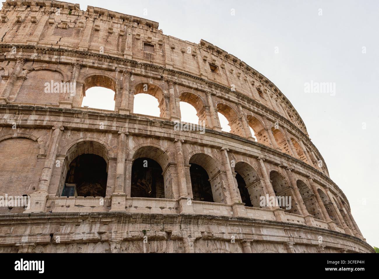 Blick aus der Nähe auf die Bögen des Kolosseums in Rom, Italien, mit verwittertem Stein, Texturen und zeitloser klassischer Architektur Stockfoto