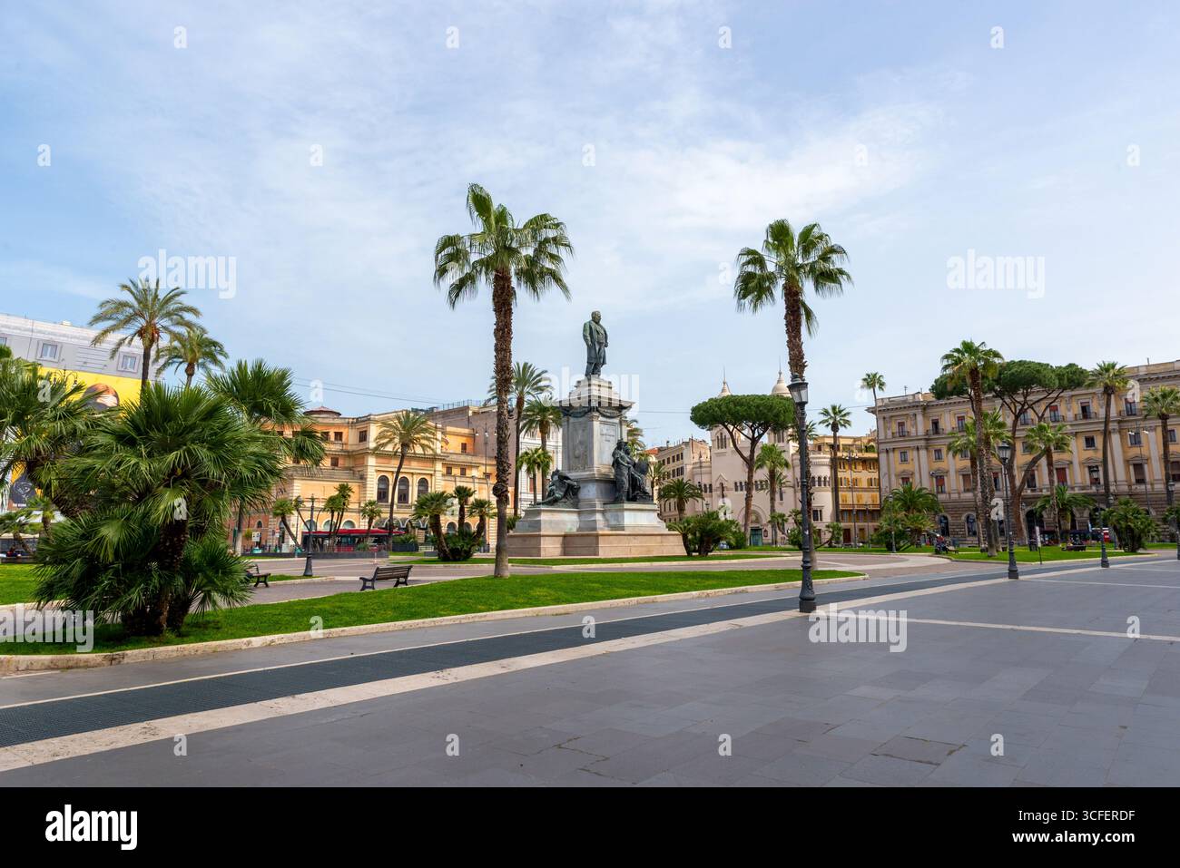 Monumentale Statue auf der Piazza Cavour, Rom, Italien, umgeben von Palmen und farbenfrohen historischen Gebäuden Stockfoto
