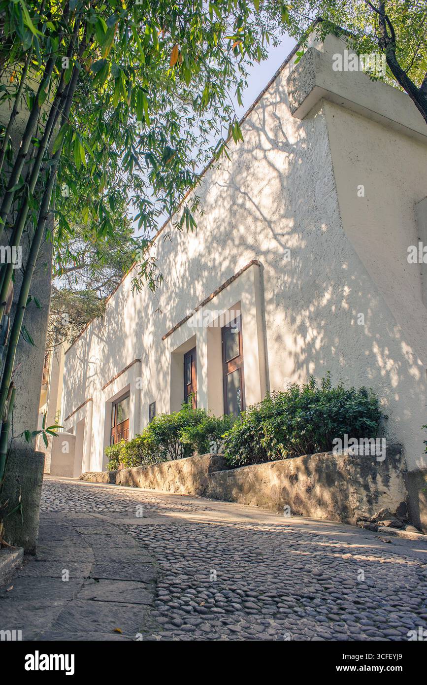 Kommerzielles Foto eines großen Präsidentenhauses im mexikanischen Stil in einer kopfsteingepflasterten Straße bei Sonnenuntergang, umgeben von Bäumen und warmem natürlichem Licht, hoch Stockfoto