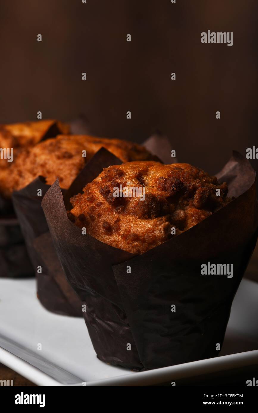 Drei frisch gebackene Kaffeekuchen-Muffins auf einer weißen Platte. Stockfoto