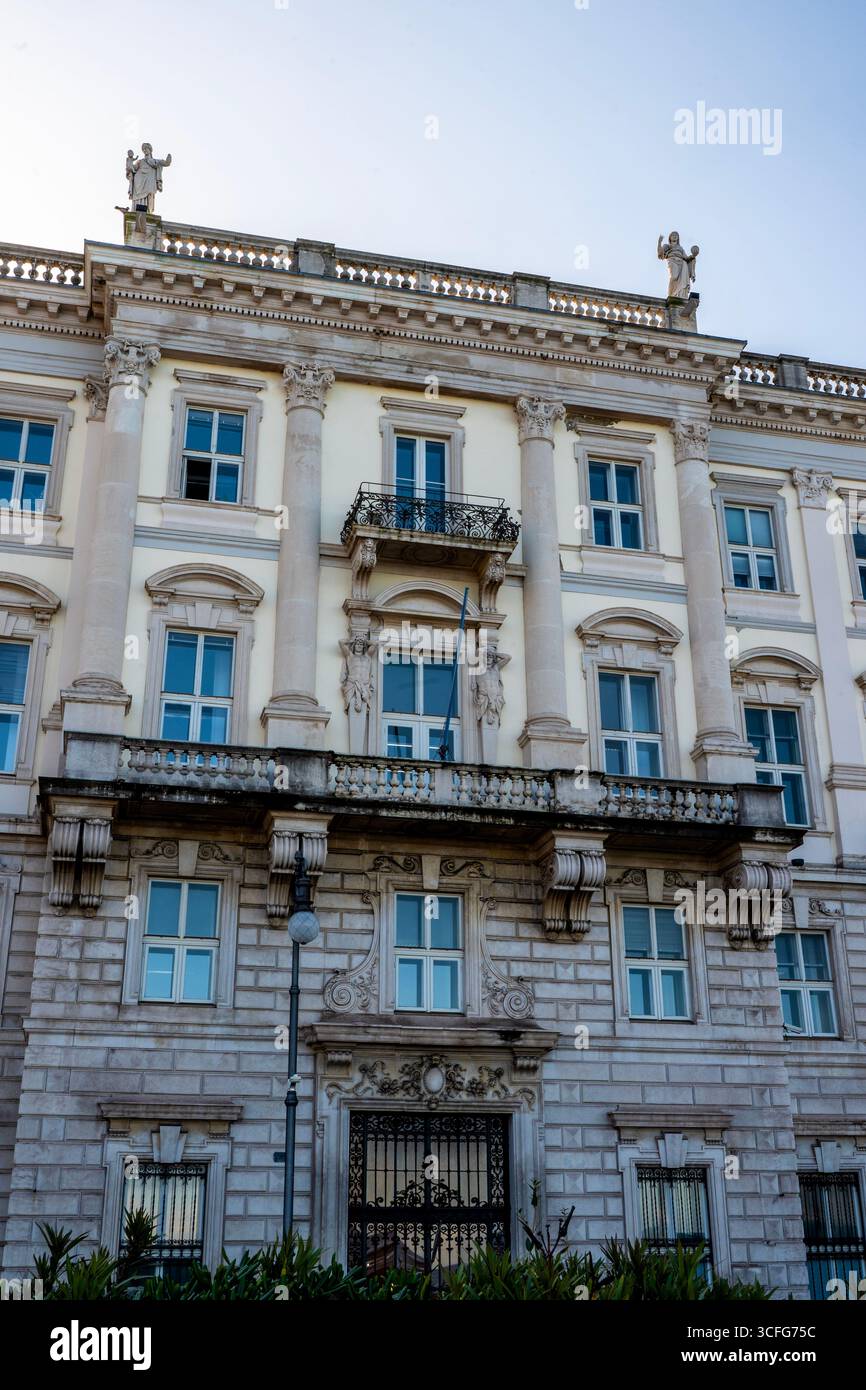 Grand Neo-Renaissance Palazzo del Lloyd Trestino auf der Piazza Unità d'Italia in Triest, Italien. Löwen, die mit Rebellen und Atlanten leben, haben einen Balkon aus Stein. Stockfoto