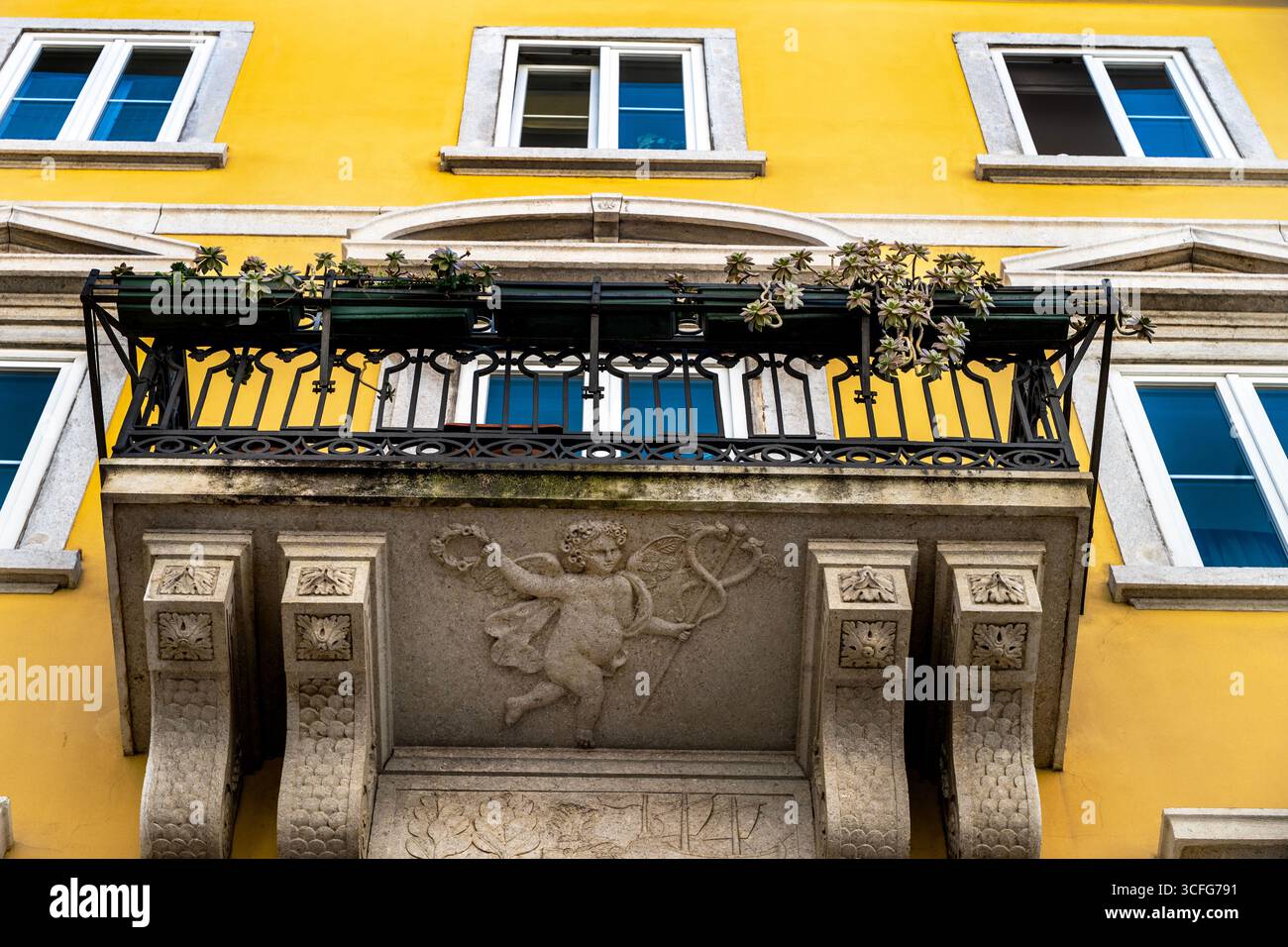 Casa Moreau verbindet neoklassizistischen und barocken Architekturstil in Triest, Italien mit einer Putto-Basreliefskulptur. Stockfoto