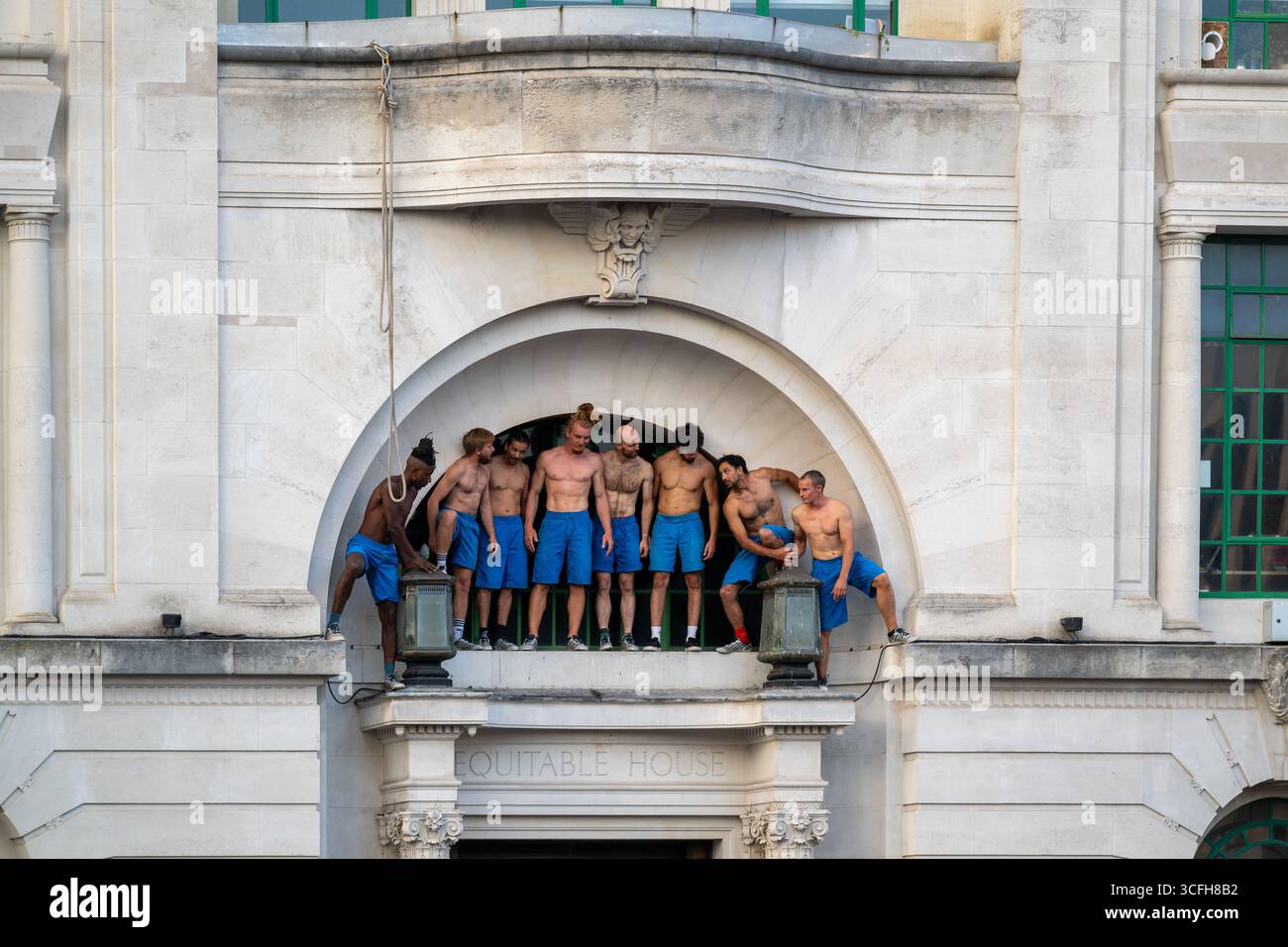 London, Großbritannien, 22. August 2025, begann das Greenwich + Docklands International Festival (GDIF) mit Above and Beyond von Lezards Bleus und The Citizens of the World Choir. Die Menschenmassen überfüllten den Beresford Square in Woolwich, um den acht Darstellern beim Tanz auf den Dächern zuzusehen. Dies ist das 30. Jahr der GDIF, die mit Freilufttheater, Zirkus und Tanz in den Parks feiert. GDIF geht weiter bis zum 8. September. Andrew Lalchan Photography/Alamy Live News Stockfoto