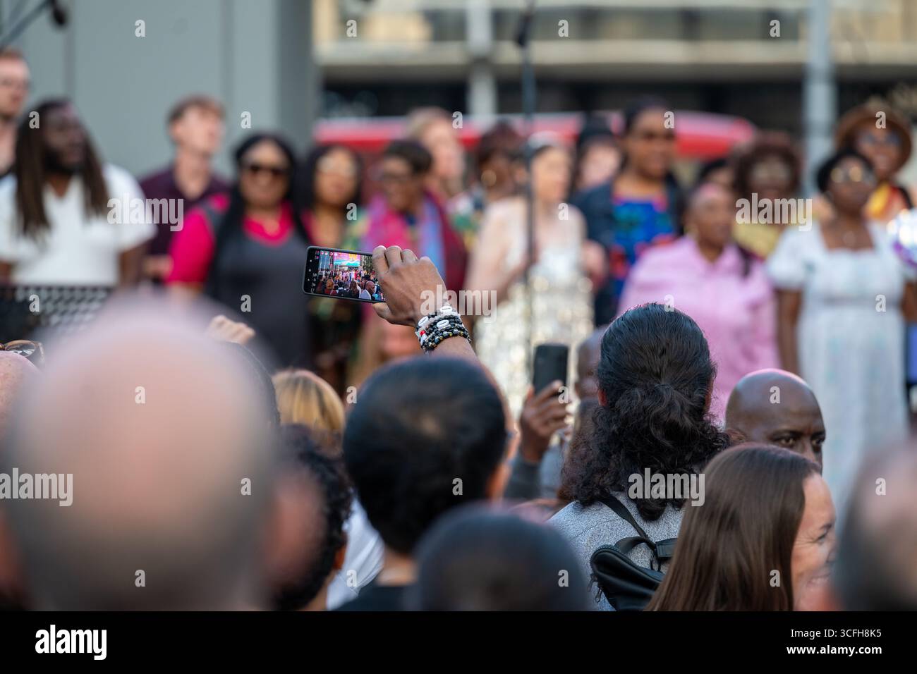 London, Großbritannien, 22. August 2025, begann das Greenwich + Docklands International Festival (GDIF) mit Above and Beyond von Lezards Bleus und The Citizens of the World Choir. Die Menschenmassen überfüllten den Beresford Square in Woolwich, um den acht Darstellern beim Tanz auf den Dächern zuzusehen. Dies ist das 30. Jahr der GDIF, die mit Freilufttheater, Zirkus und Tanz in den Parks feiert. GDIF geht weiter bis zum 8. September. Andrew Lalchan Photography/Alamy Live News Stockfoto