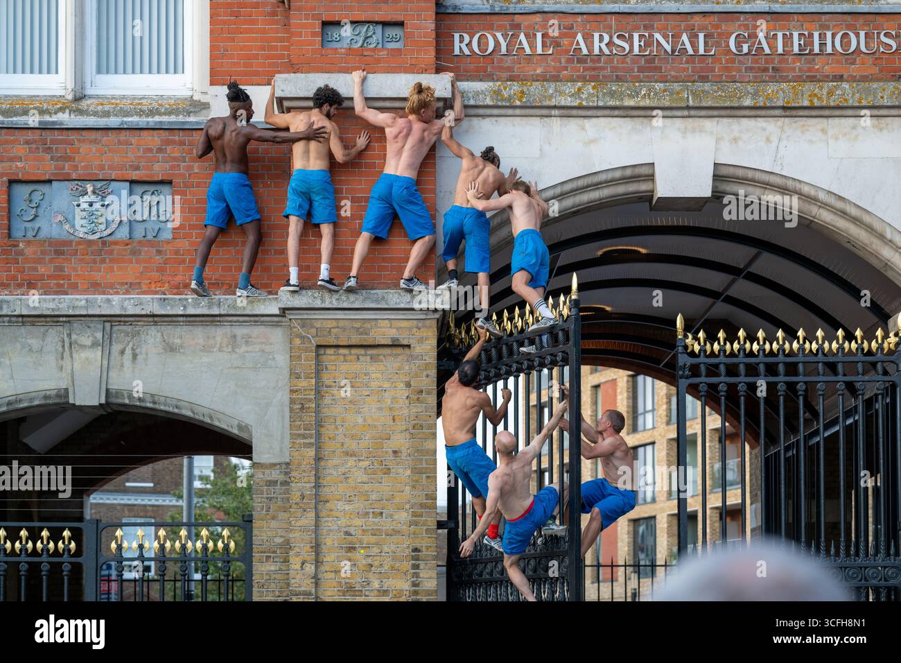 London, Großbritannien, 22. August 2025, begann das Greenwich + Docklands International Festival (GDIF) mit Above and Beyond von Lezards Bleus und The Citizens of the World Choir. Die Menschenmassen überfüllten den Beresford Square in Woolwich, um den acht Darstellern beim Tanz auf den Dächern zuzusehen. Dies ist das 30. Jahr der GDIF, die mit Freilufttheater, Zirkus und Tanz in den Parks feiert. GDIF geht weiter bis zum 8. September. Andrew Lalchan Photography/Alamy Live News Stockfoto