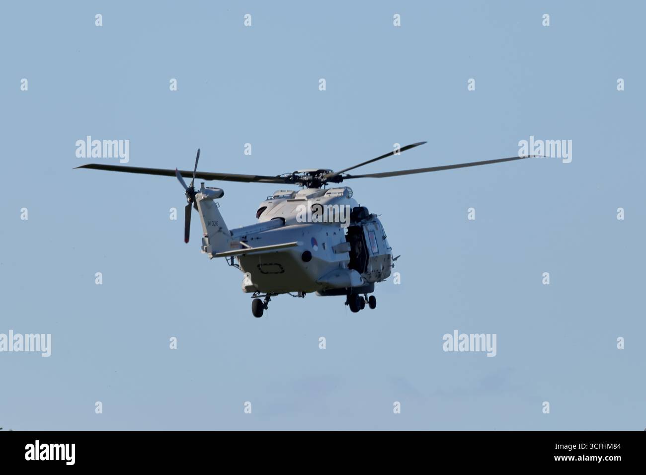 Royal Netherlands Navy NH90 N-326 nähert sich Amsterdam, Niederlande, Dreiviertelansicht mit offener Seitentür und Fahrwerk bei Tageslicht. Stockfoto