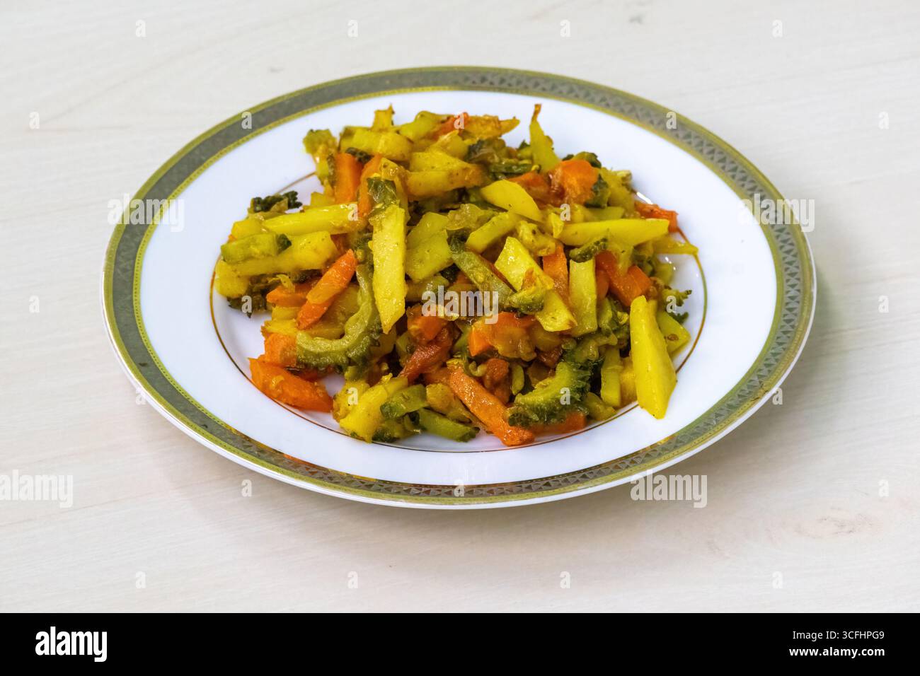 Gekochte Kartoffeln, Karotten und bittere Kürbis-Krapfen auf einem weißen Teller. Diese Gemüsesorten werden gehackt, gemischt und dann gebraten. Dieses Bangladeschische Gericht ist es Stockfoto