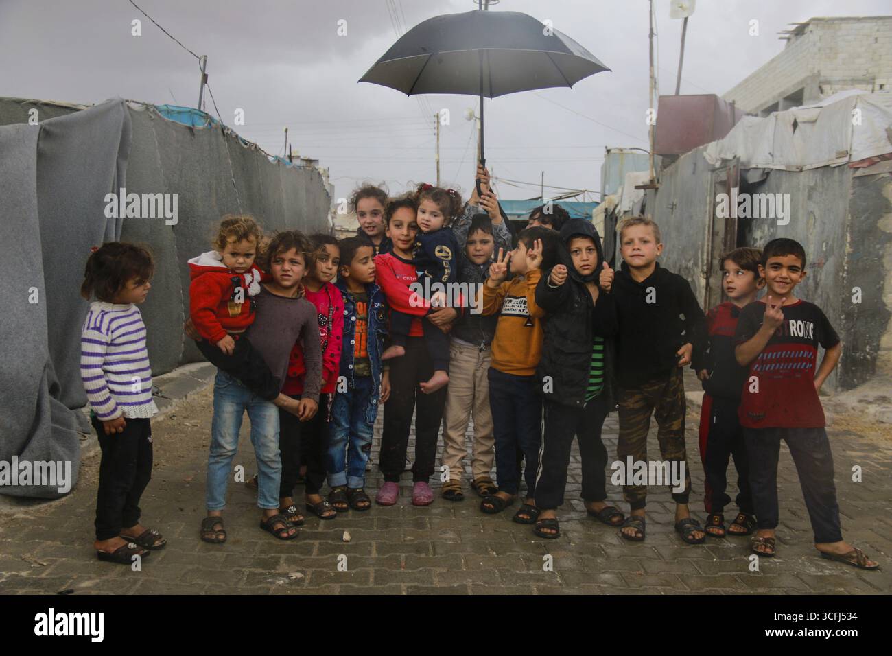 Syrische Kinder im Flüchtlingslager machen ein Gruppenfoto unter dem Regen am Weltkindertag. Aleppo, Syrien, 2. März 2017, Aleppo, Syrien Stockfoto