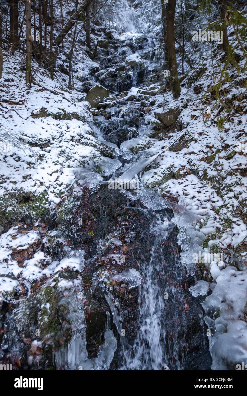 Gefrorener Wasserfall im Wald mit Schnee- und Eisstrukturen, Kamptal Waldviertel Österreich Stockfoto