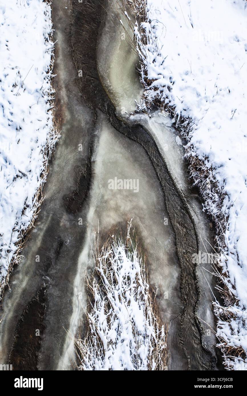 Ein gefrorener Bach mit Schneedecke in abstrakter Form, Kamptal Waldviertel Österreich Stockfoto