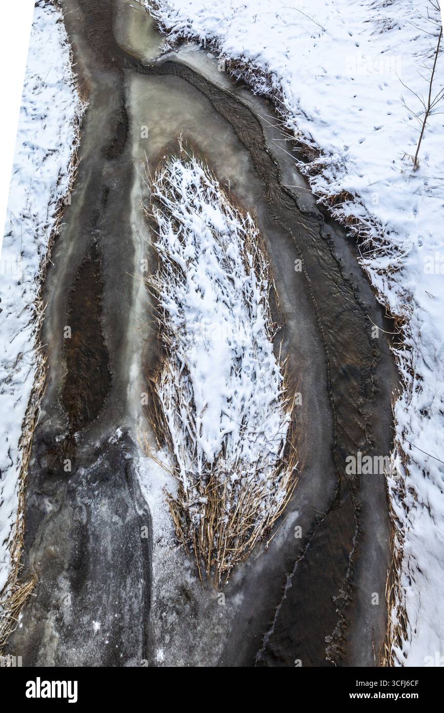 Luftaufnahme eines teilweise gefrorenen Baches, umgeben von Schnee, Kamptal Waldviertel Austria Stockfoto