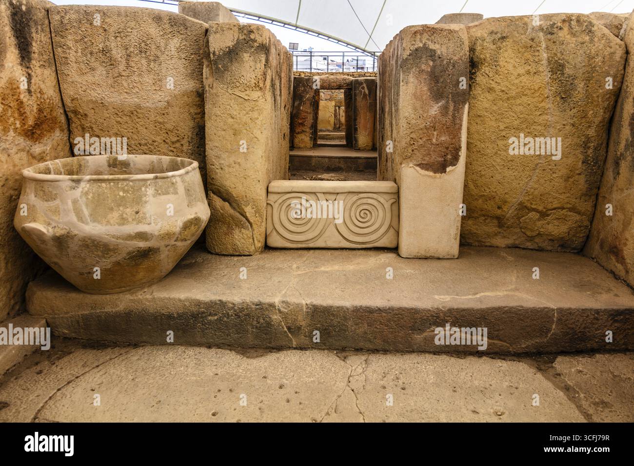 Dekorativer Stein mit Doppelspirale und Tongefäß, Megalithtempel von Hal Tarxien, 3250-2500 v. Chr., UNESCO-Weltkulturerbe, Tarxien, Malta Stockfoto