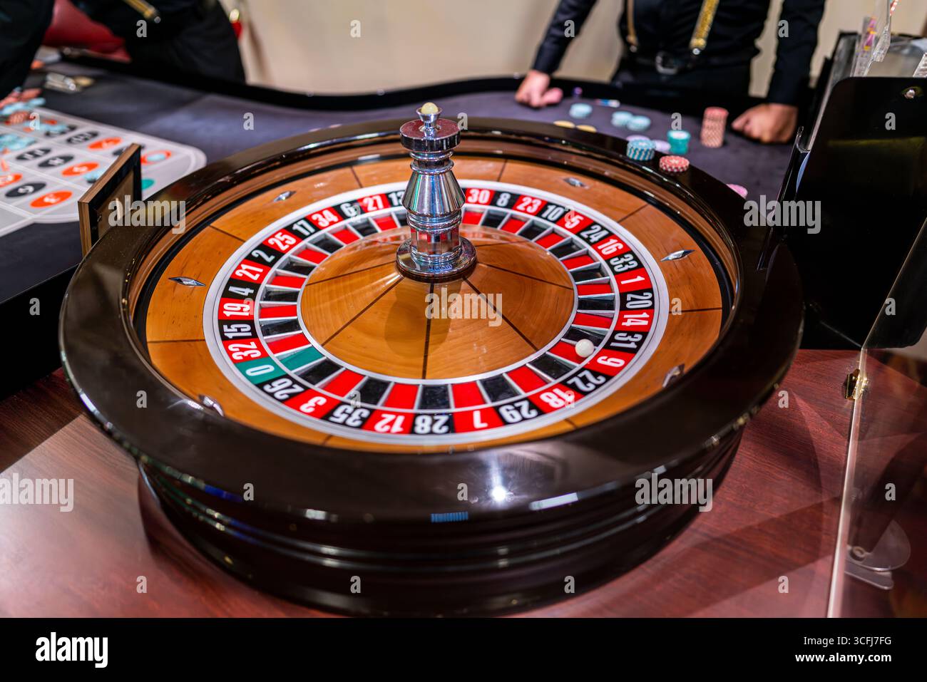 Roulette-Rad im Casino mit Dealer und Chips Stockfoto