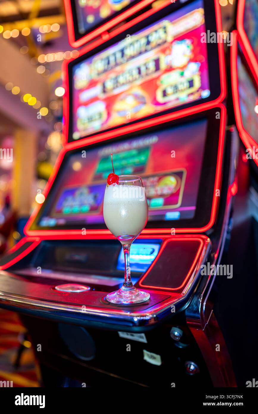Cocktailglas mit Kirsche am Spielautomaten im Kasino Stockfoto