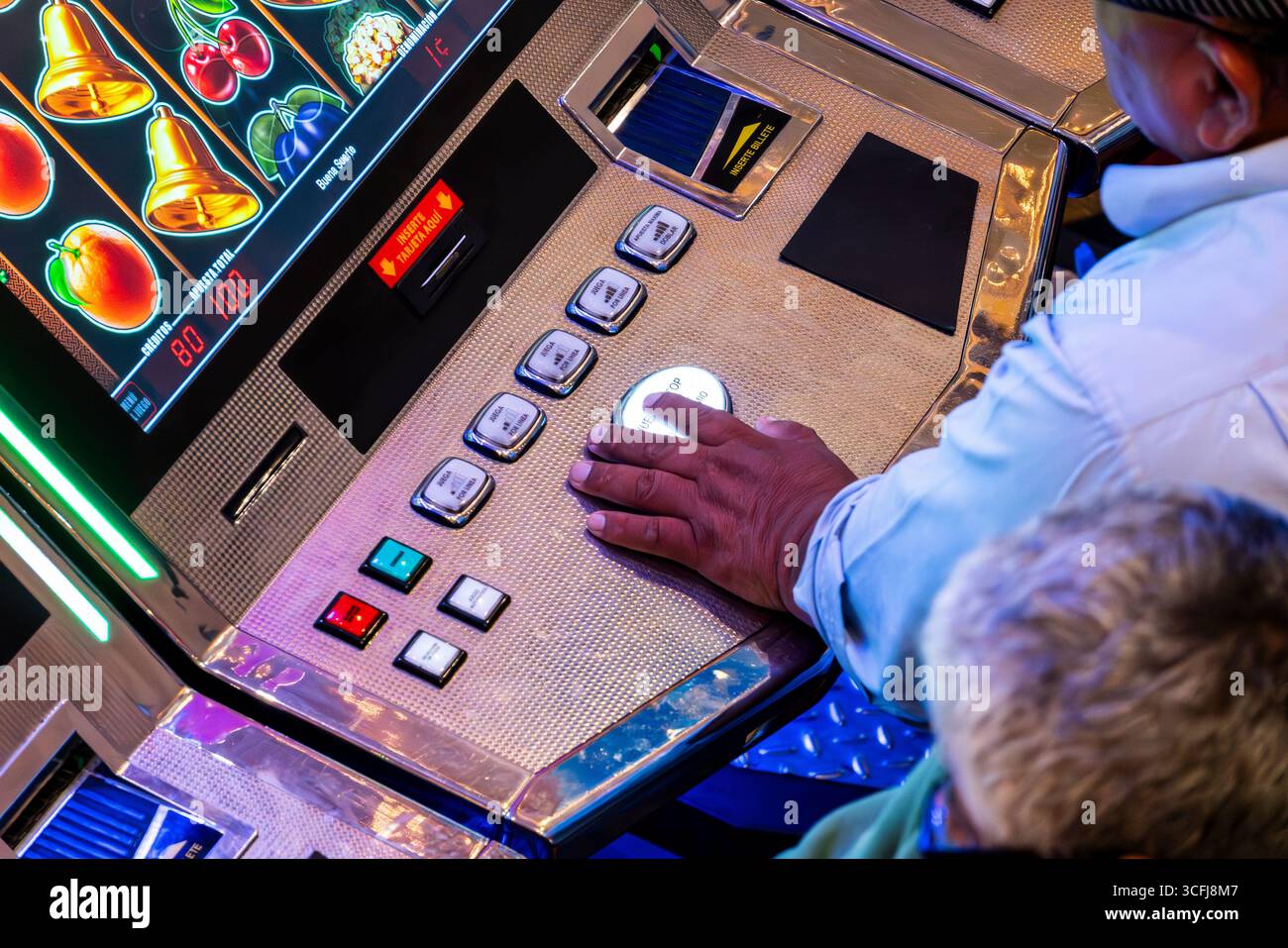 Drücken Sie mit der Hand den Knopf am Spielautomaten im Casino Stockfoto