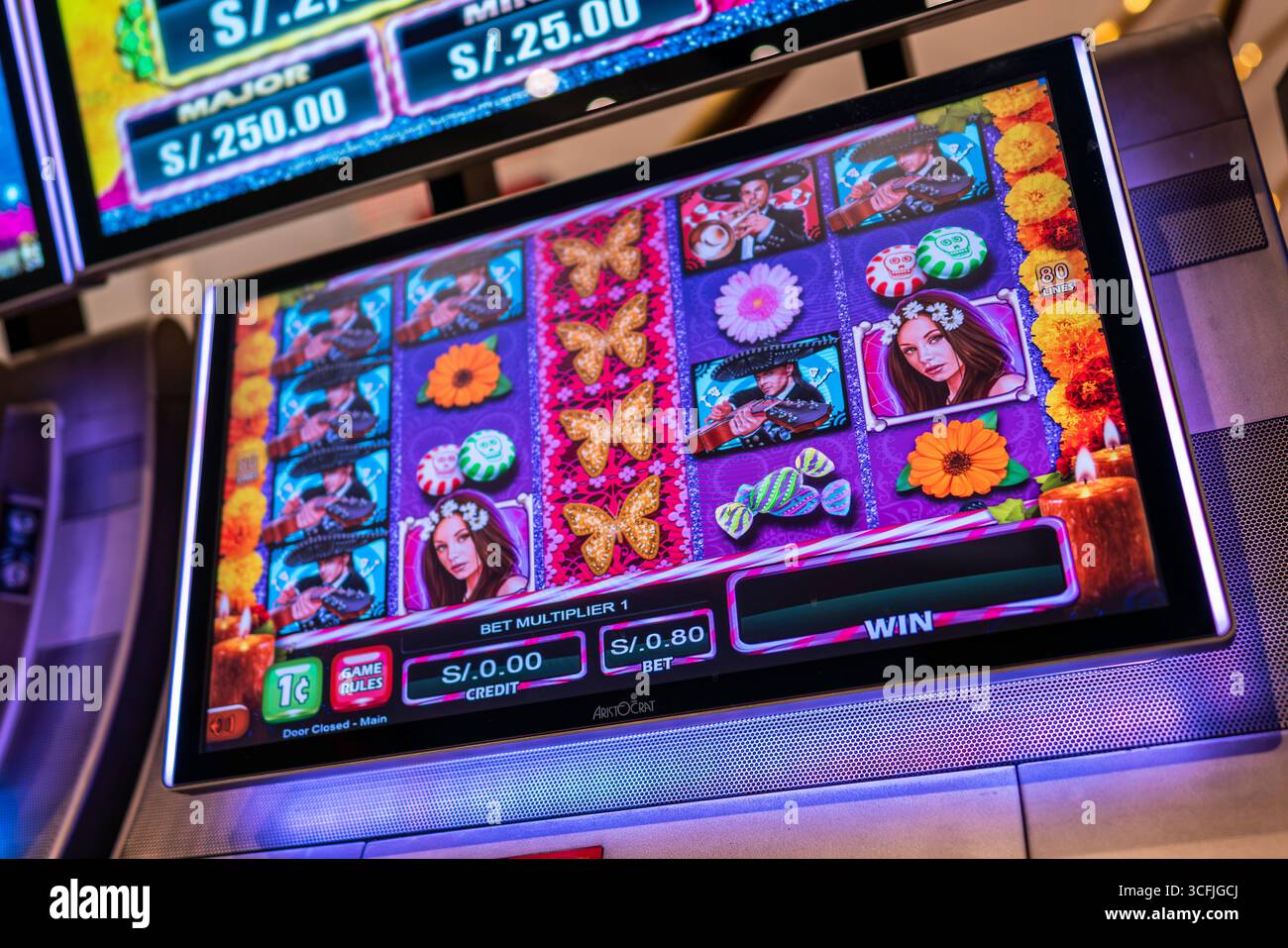 Nahaufnahme der Spielautomaten von Sweet Skulls mit Schmetterlingen, Blumen, Süßigkeiten, Mariachi und Schädelsymbolen, die von Day of the Dead inspiriert sind. Stockfoto