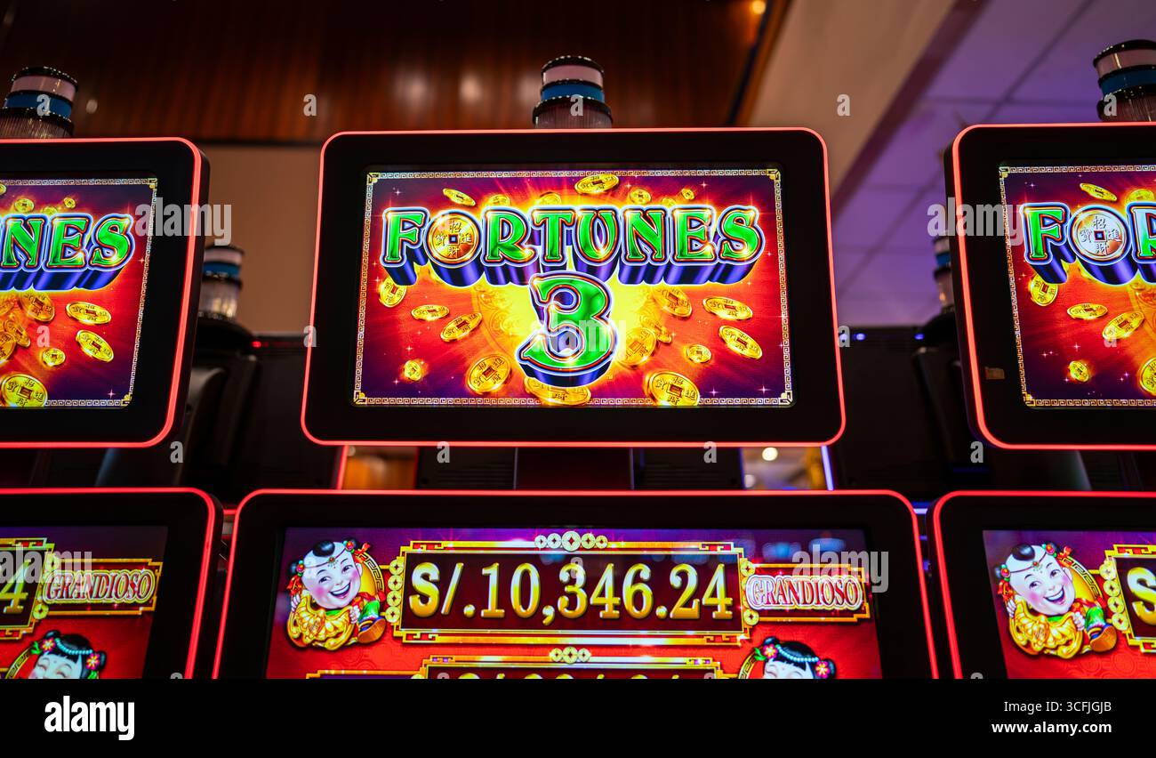 Nahaufnahme eines Spielautomaten-Bildschirms in einem Casino mit dem „Fortune 3“-Spiellogo mit goldenen Münzen und farbenfrohen Grafiken. Stockfoto