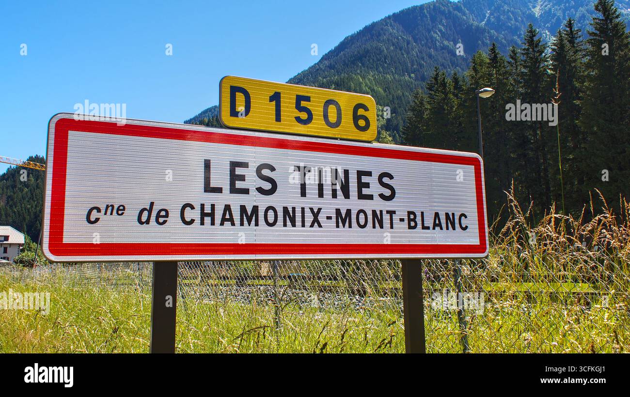 Stadteingangsschild von Les Tines, einem Viertel von Chamonix, mit Wald und Hügel im Hintergrund – ländliche Alpenlandschaft in den französischen Alpen. Stockfoto
