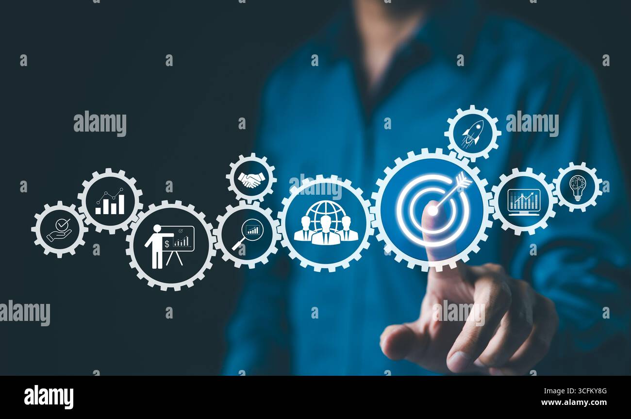 Visualisierung von Geschäftsstrategie und Zielkonzepten. Geschäftsmann mit der virtuellen Schnittstelle von Zahnrädern, die Geschäftsstrategien und -Ziele repräsentieren Stockfoto