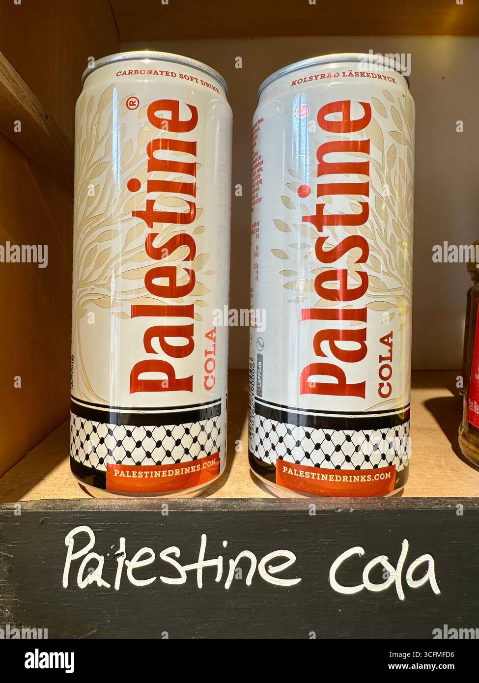 Zwei Dosen Palestine Cola mit einem handgeschriebenen Schild mit der Aufschrift Palestine Cola unten, eine Ausstellung in einem Laden - Smartphone-aufgenommenes Stockfoto