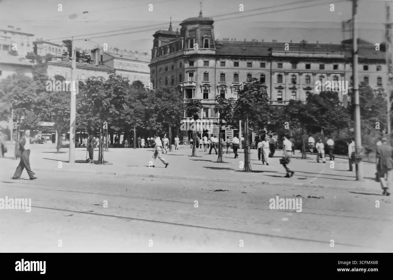 Ein altes Foto von der Rijeka Promenade und dem Continental Hotel, dem ältesten Hotel in Rijeka. Das Foto zeigt zahlreiche Passanten in Sommerkleidung, die durch die von Bäumen gesäumte Allee vor dem Hotel spazieren. 1953. Stockfoto