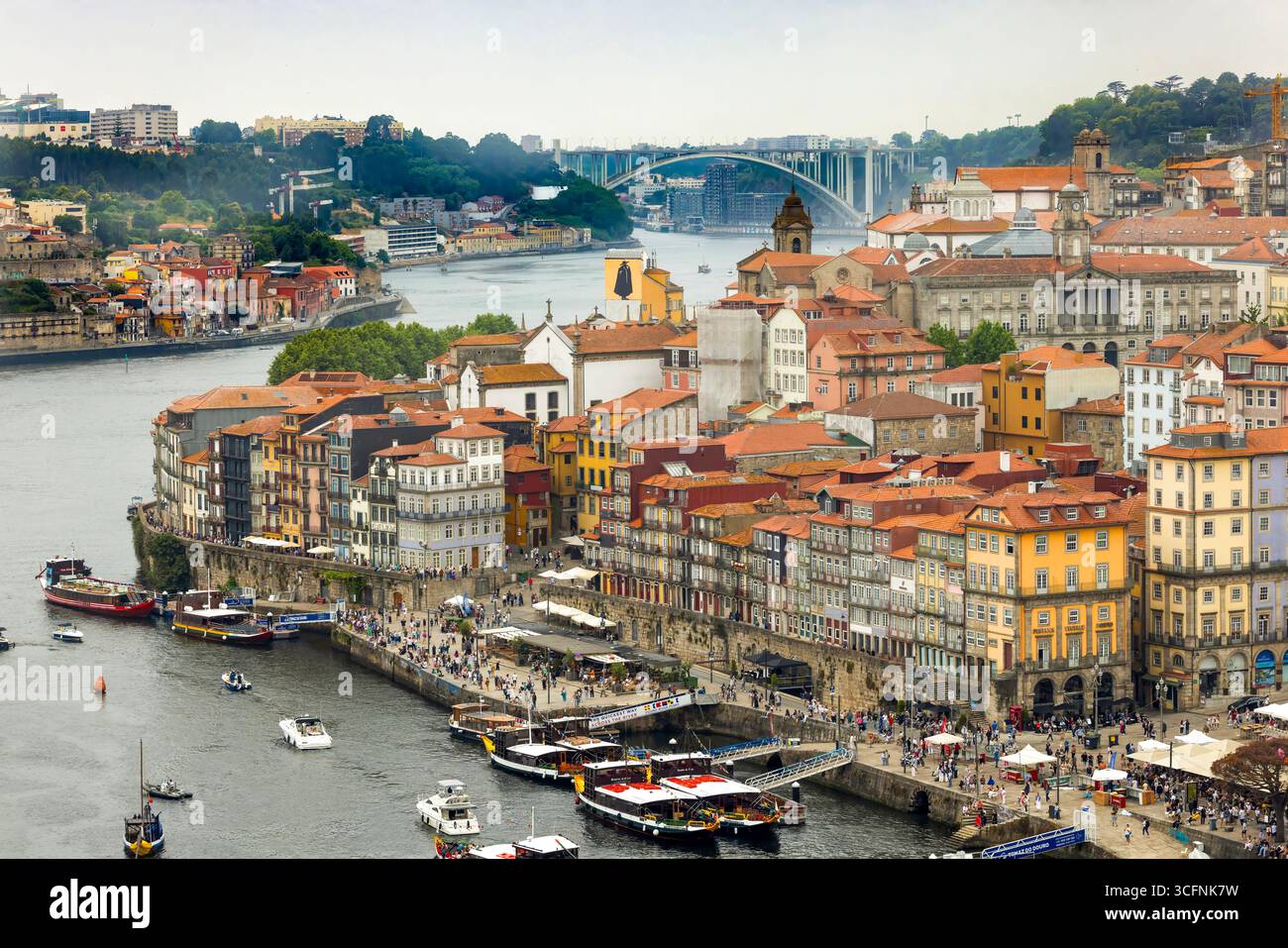 Ribeira-Platz und Cais da Ribeira-Ufer am Fluss Douro in Porto, Portugal, mit der Brücke Ponte da Arrábida im Hintergrund Stockfoto