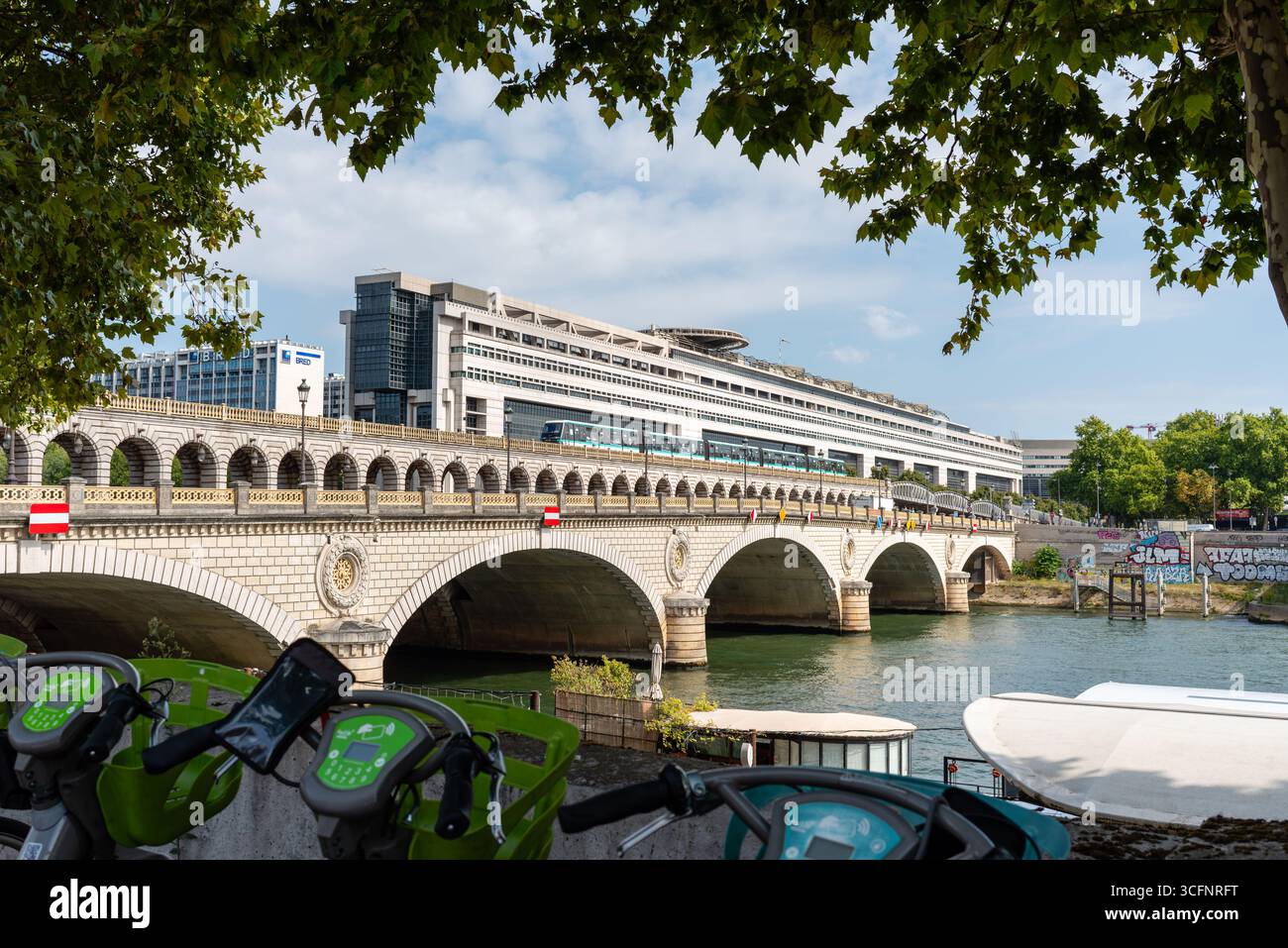 Eine U-Bahn-Linie 6 überquert Pont de Bercy mit dem Gebäude des Wirtschafts- und Finanzministeriums Stockfoto Eine U-Bahn-Linie 6 überquert Pont de Bercy mit dem Gebäude des Wirtschafts- und Finanzministeriums Stockfoto