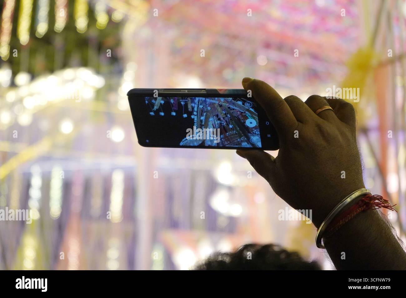 Aufnahmen der Durga Puja Festlichkeiten auf einem Smartphone Stockfoto
