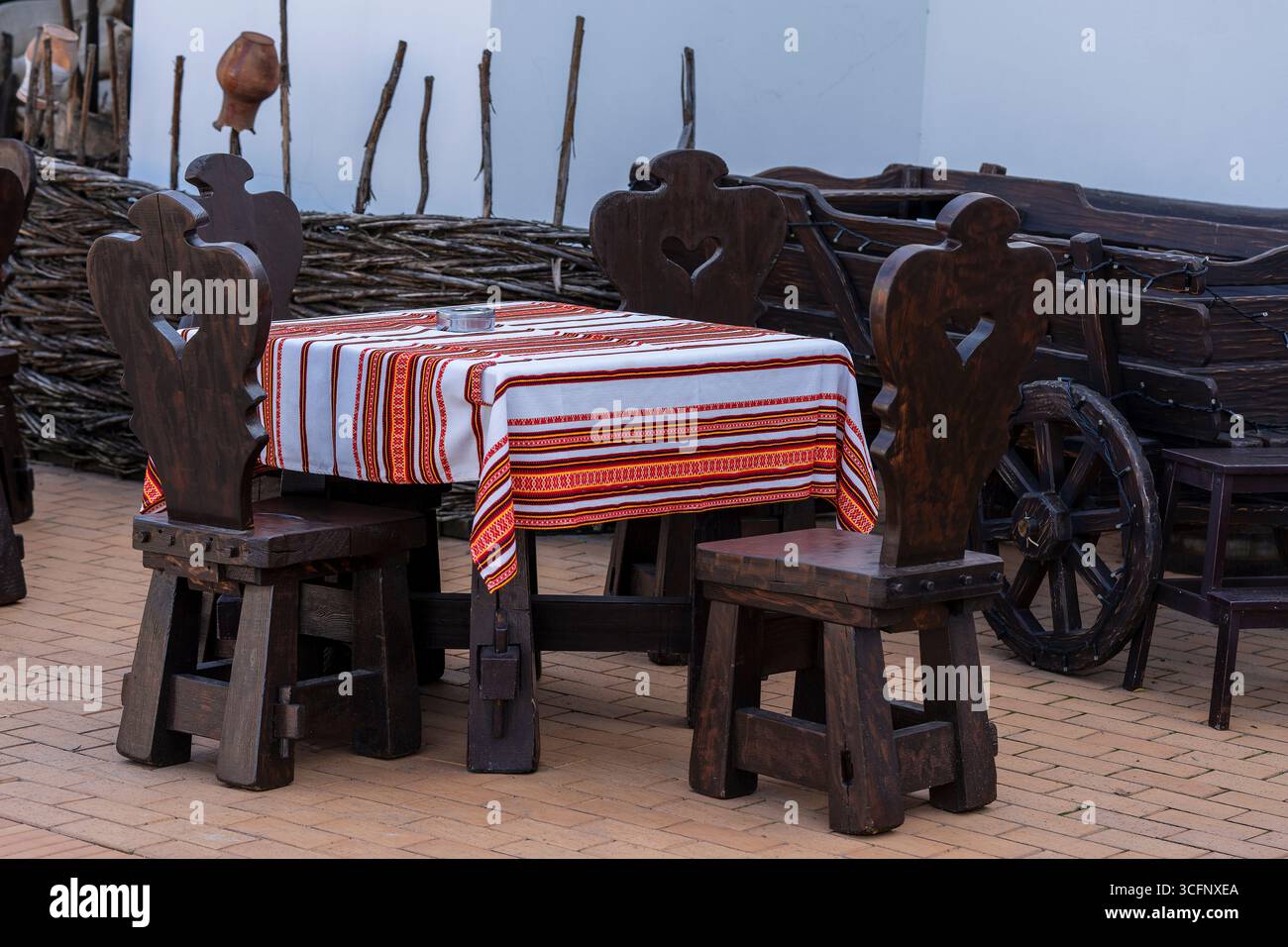 Traditionelles ukrainisches Straßenrestaurant im rustikalen Stil mit Holztischen und Stühlen im Zentrum von Kiew für Touristen, Ukraine. Nahaufnahme Stockfoto