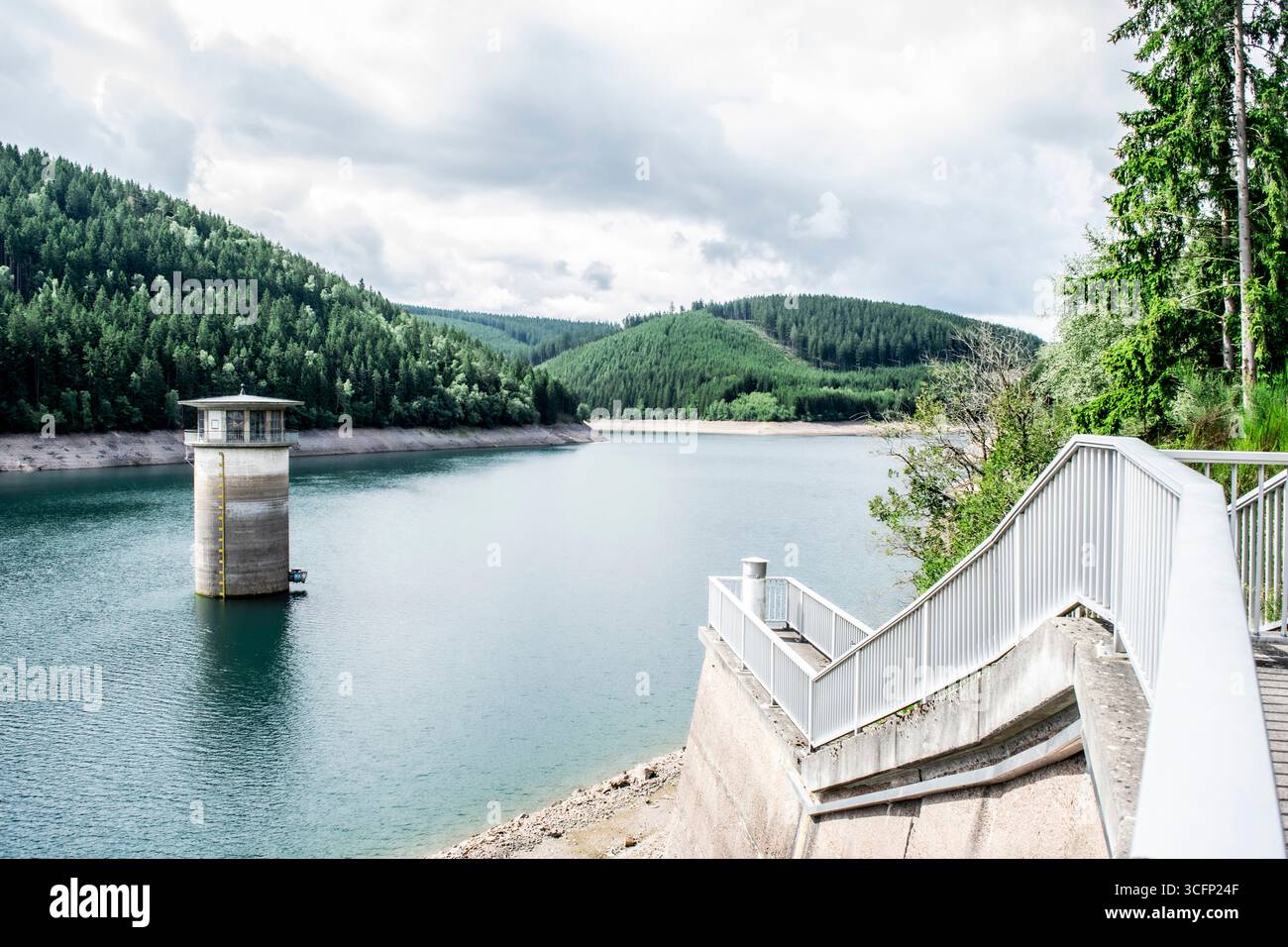Entdecken Sie die ruhige Schönheit des Söse-Damms im deutschen Harz. Dieses Bild fängt den ruhigen See und die üppige Waldlandschaft ein. Stockfoto