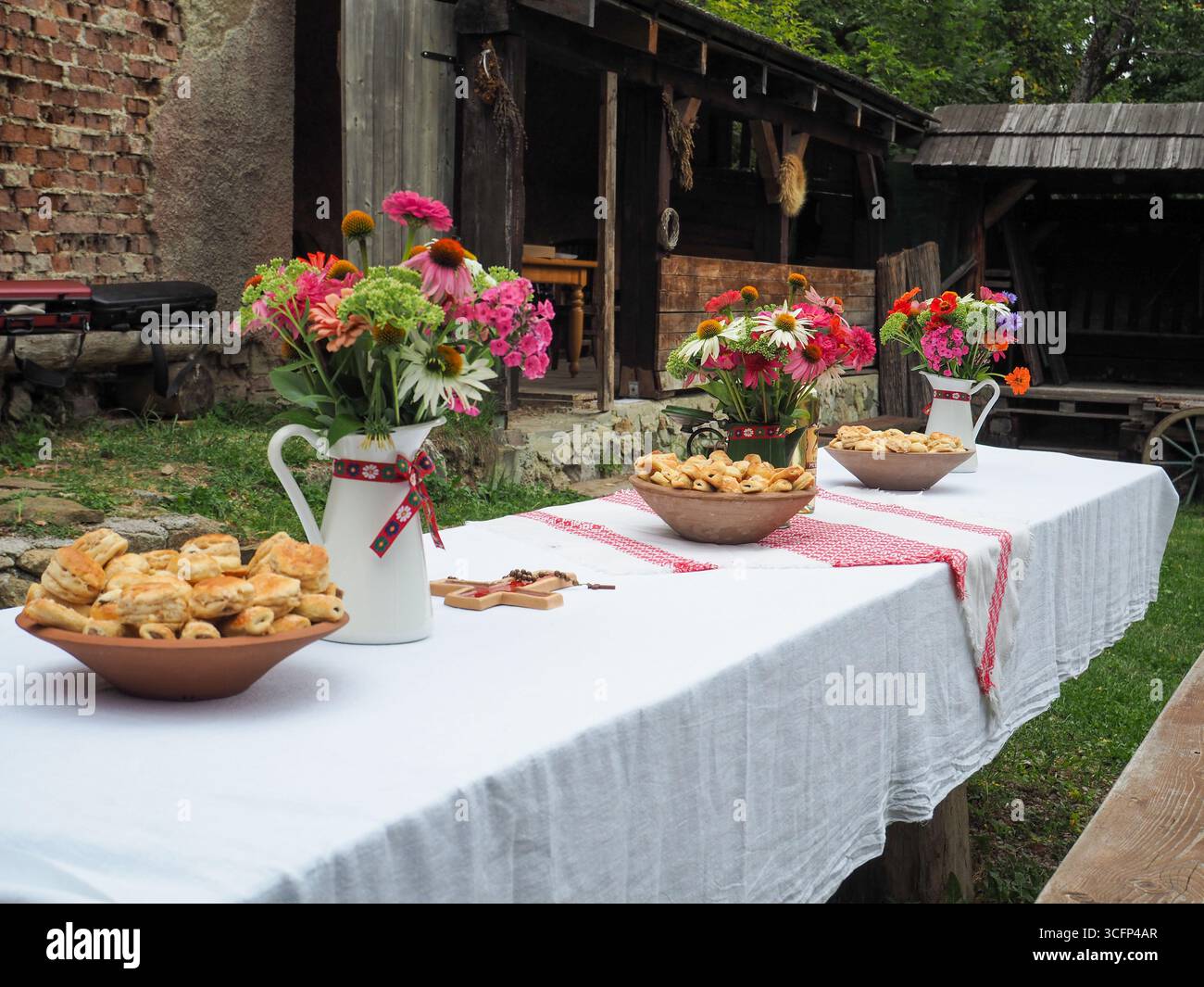 Blick auf den traditionellen Dorftisch mit Blumen und Gebäck im UNESCO-Weltkulturerbe Vlkolínec, Slowakei Stockfoto