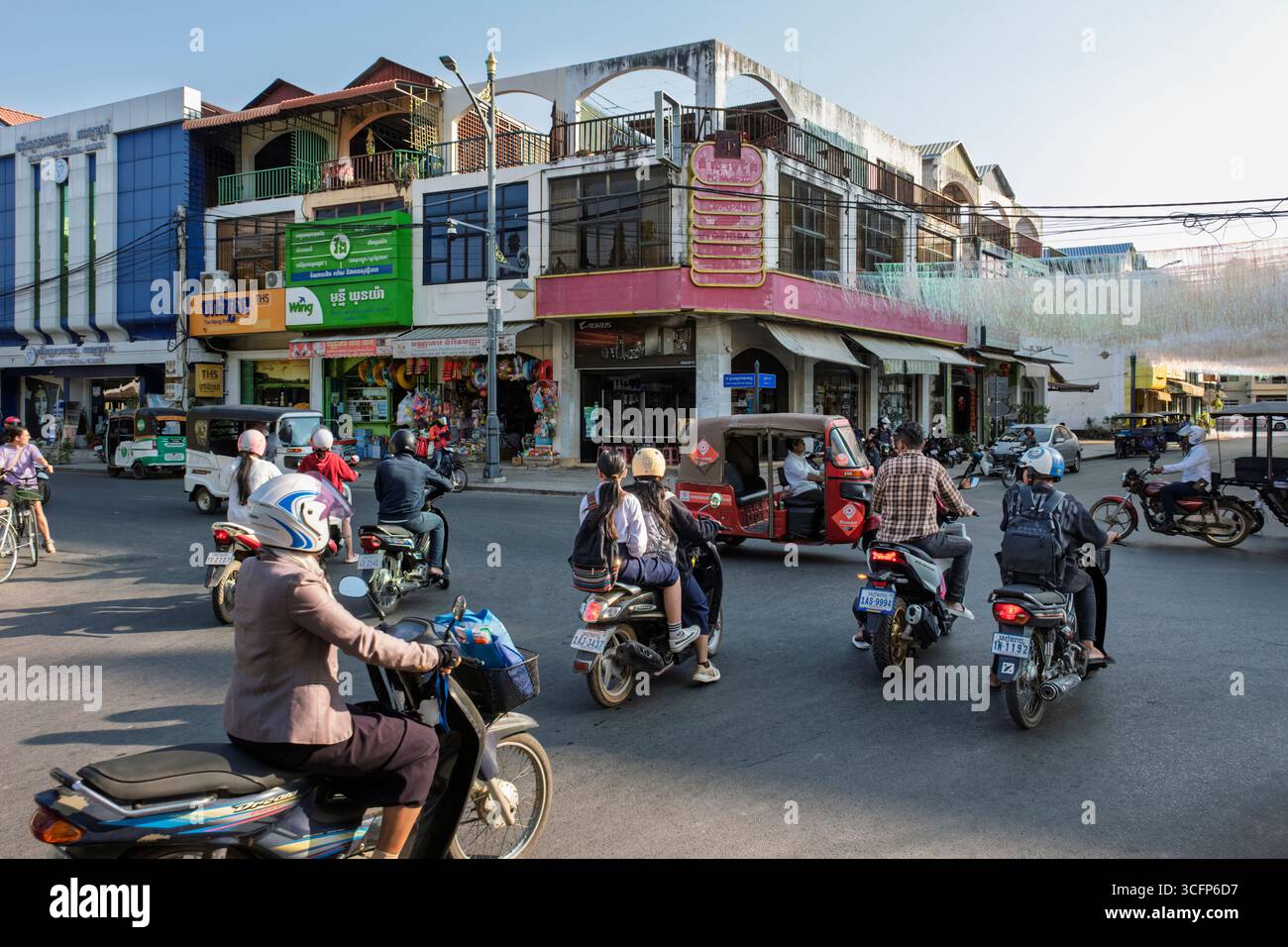 Motorräder und Tuk Tuks an einer geschäftigen Kreuzung in Siem Reap, Kambodscha Stockfoto