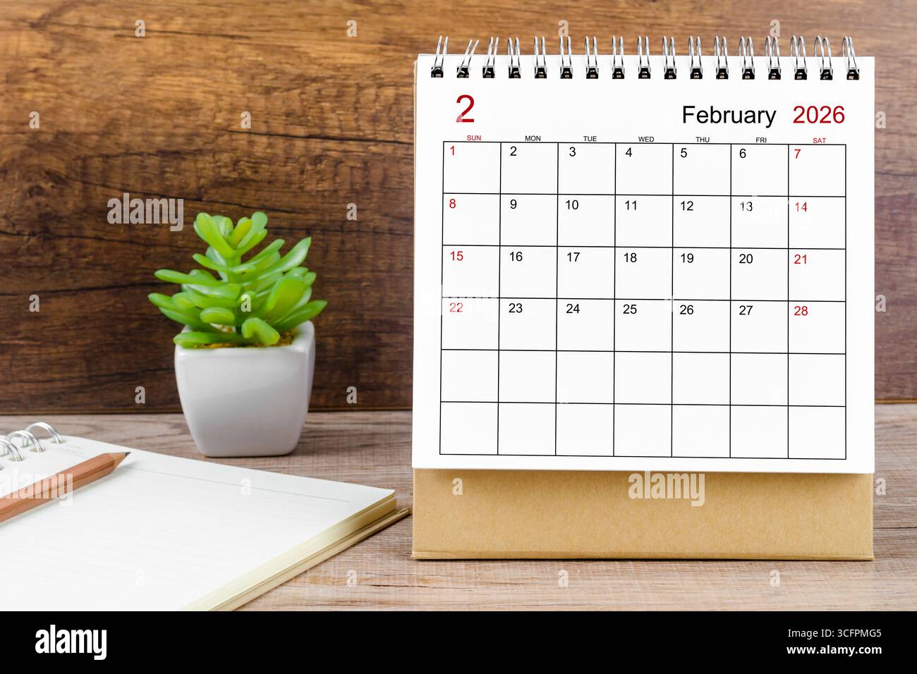 Februar 2026 Schreibtischkalender auf Holzarbeitstisch. Stockfoto