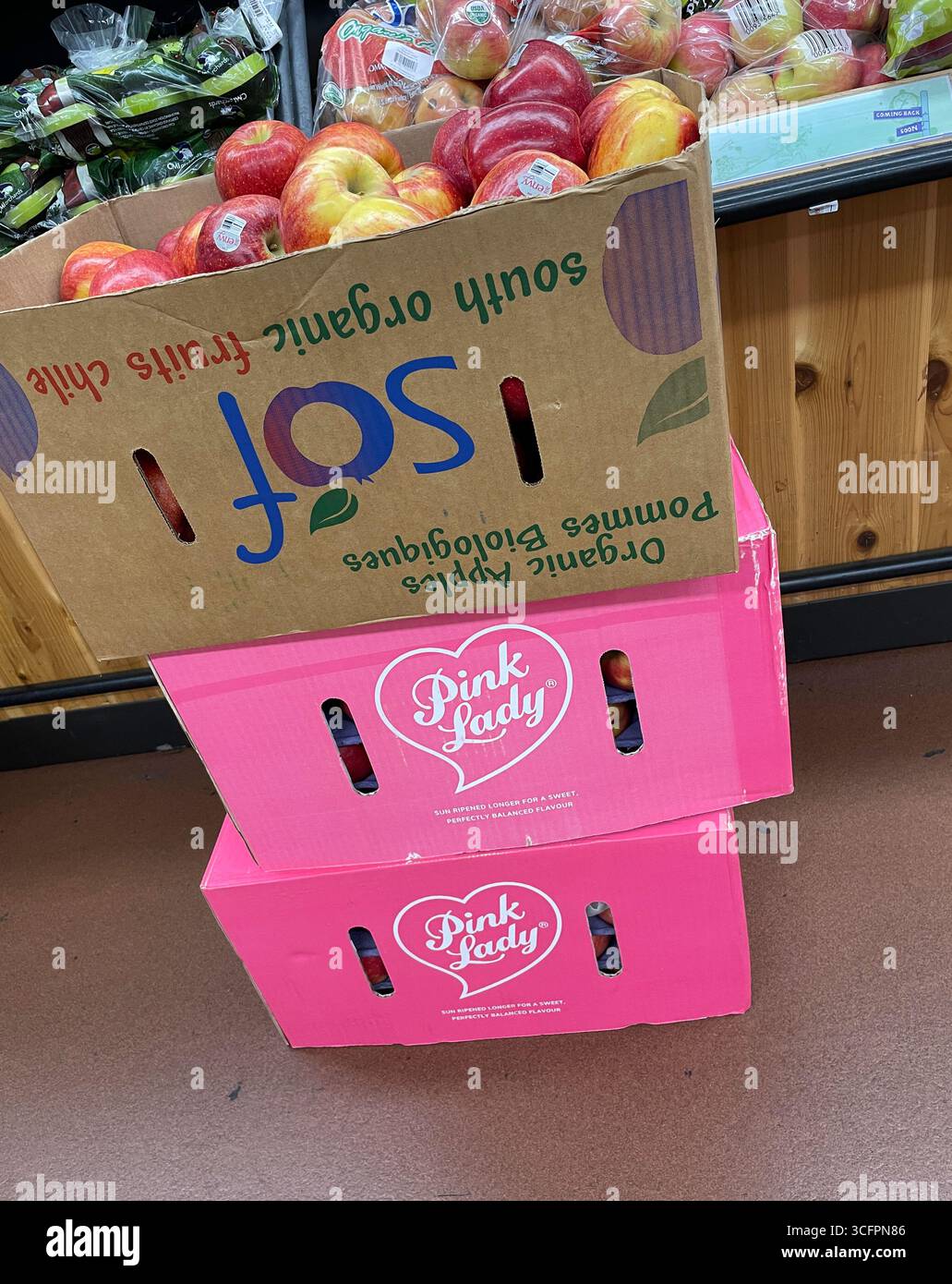 Pink Lady Apple Boxen sind leuchtend rosa gefärbt und stapeln sich in einem Supermarkt, 2025, USA Stockfoto