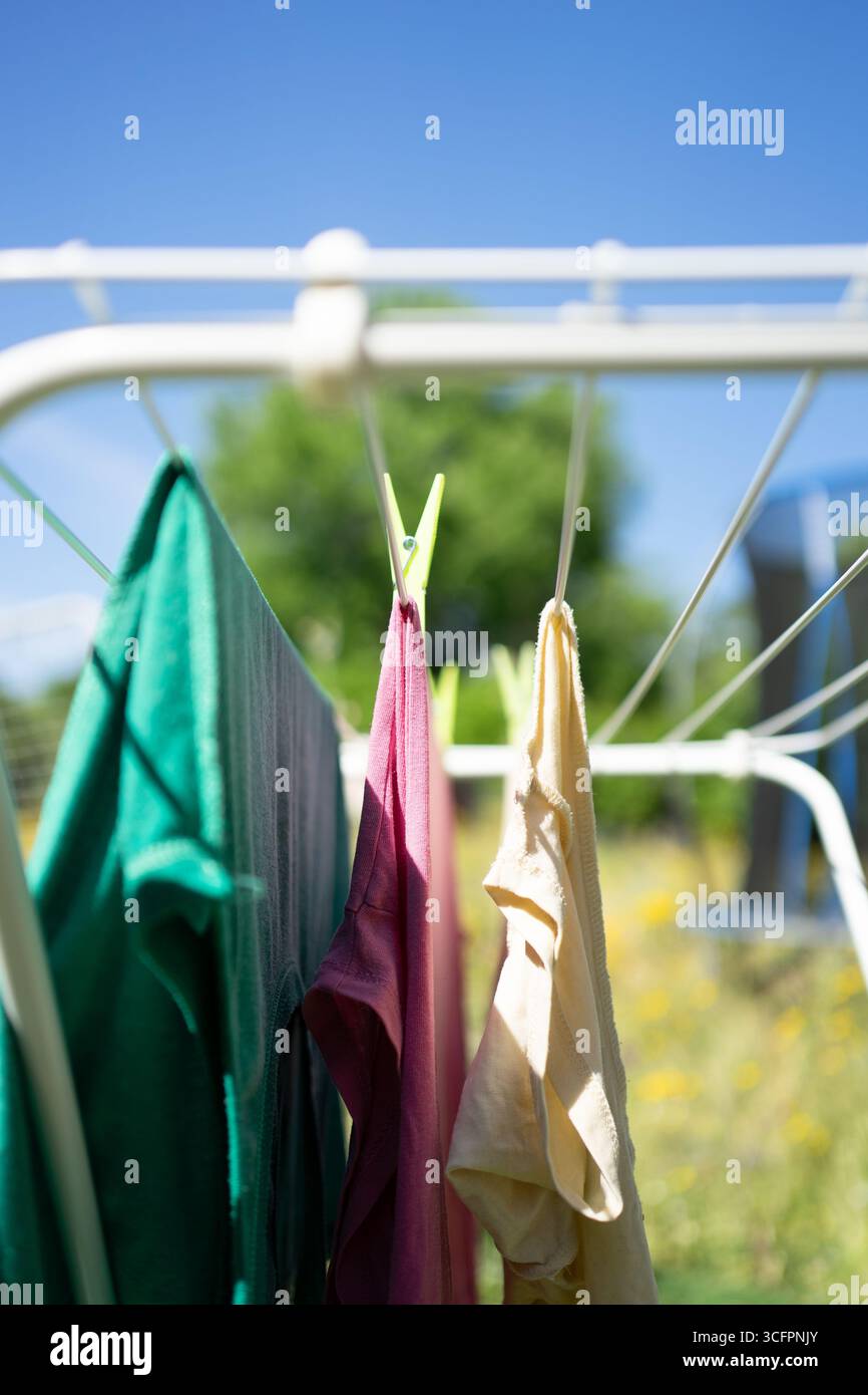 Saubere Kleidung trocknet an einem sonnigen Tag auf einem Wäscheleinen Stockfoto