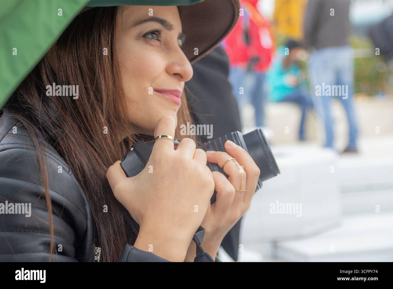 Seitenprofil einer Touristenfrau mit Kamera in einer Menschenmenge Stockfoto