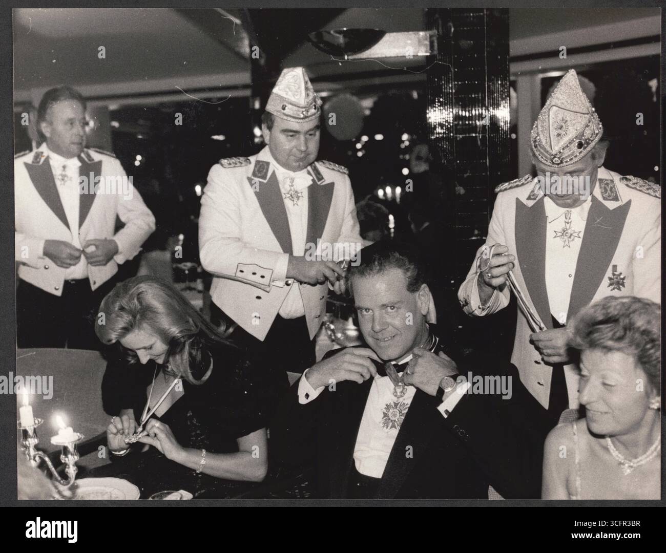 Köln - Karnevalsveranstaltung in der Bastei (Kölner Restaurant am Rheinufer) - im Bild: Der Gastronom und Bastei-Betreiber Jochen Blatzheim erhält vom Präsidenten der Kölner Prinzengarde Hans Becker (R. / Stehend) und dessen Stellvertreter Heinz-Jürgen Palm (l. stehend) den Sessionsorden der Prinzengarde. Links neben Blatzheim sitzt dessen Ehefrau Stockfoto