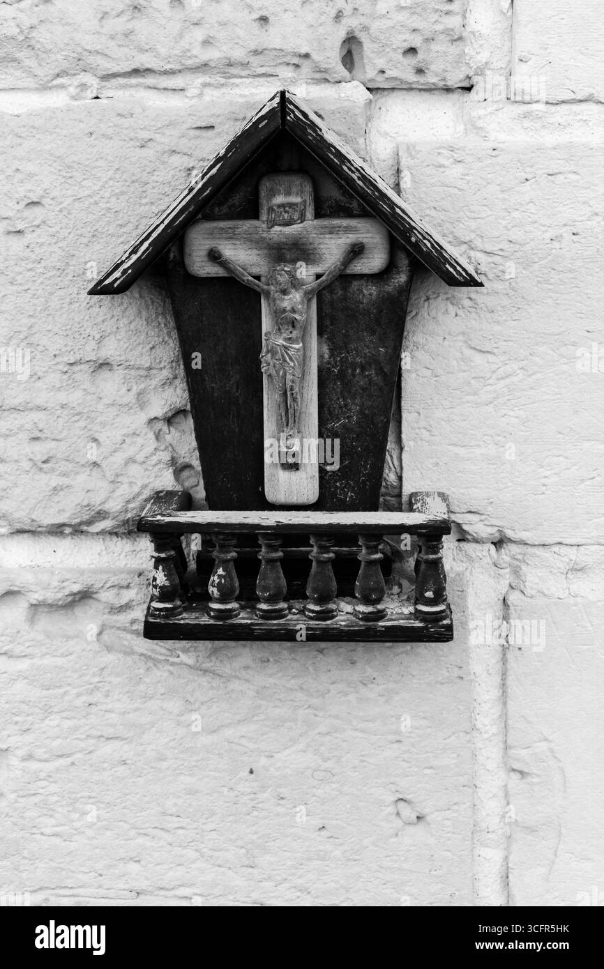 Schwarzes und weißes religiöses Kruzifix-Symbol auf der strukturierten Steinmauer Stockfoto Schwarzes und weißes religiöses Kruzifix-Symbol auf der strukturierten Steinmauer Stockfoto