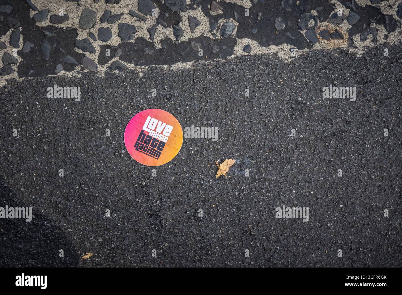 LONDON, GROSSBRITANNIEN. August 2025. Ein Aufkleber mit der Aufschrift „Love Music Hate Rassismus“ auf der Straße entlang der Paraderoute während des Familientages beim Notting Hill Carnival. Die jährliche Feier der karibischen Kultur im Westen Londons zeigt oft Botschaften für politische und soziale Gerechtigkeit neben Musik, Tanz und Festlichkeiten. Quelle: Pete Speller/Alamy Live News Stockfoto