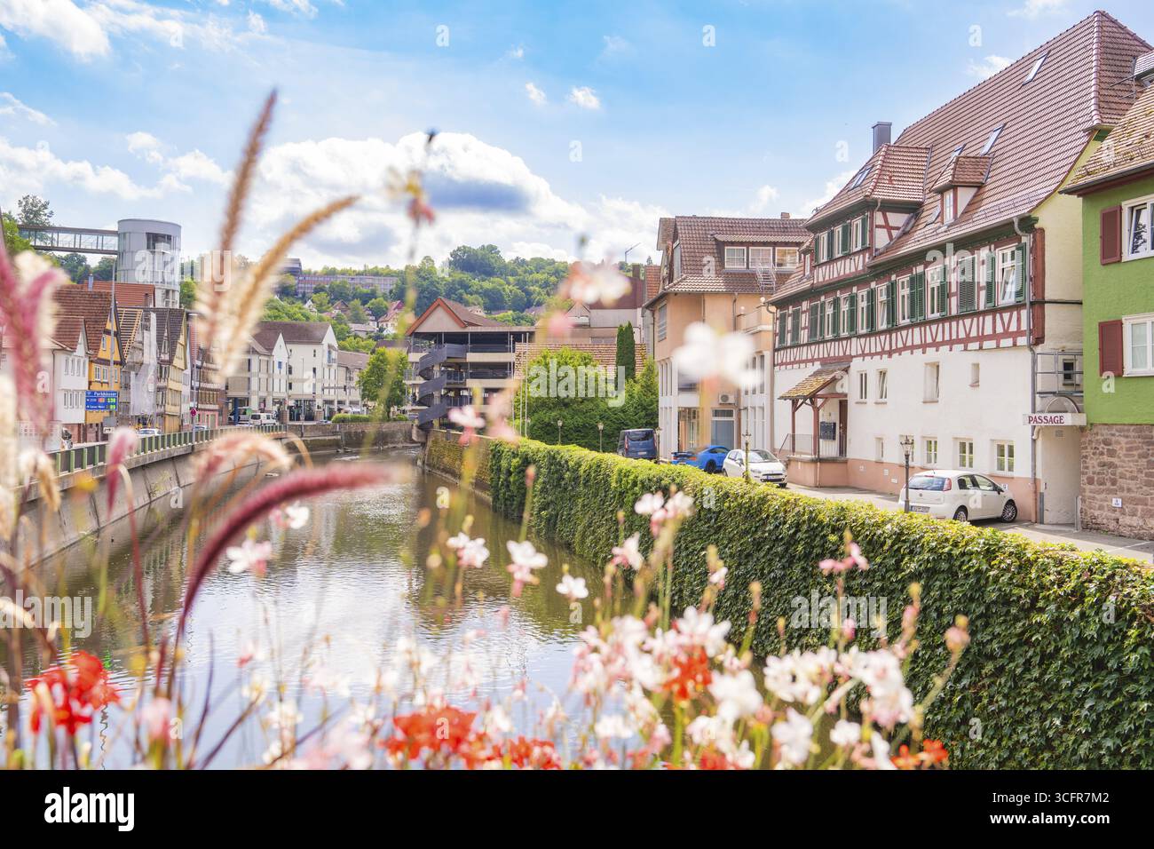 Idyllischer Flussblick mit Fachwerkhäusern und Blumen in sommerlicher Atmosphäre, Kleinstadt Perle Calw, Schwarzwald, Deutschland Stockfoto